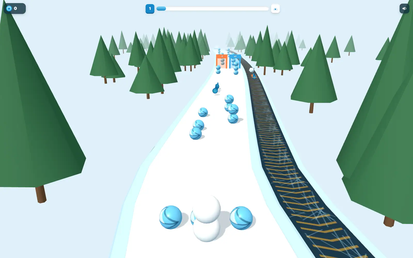 A snowy downhill run between pine trees, blue obstacles on the piste and a railway line alongside.